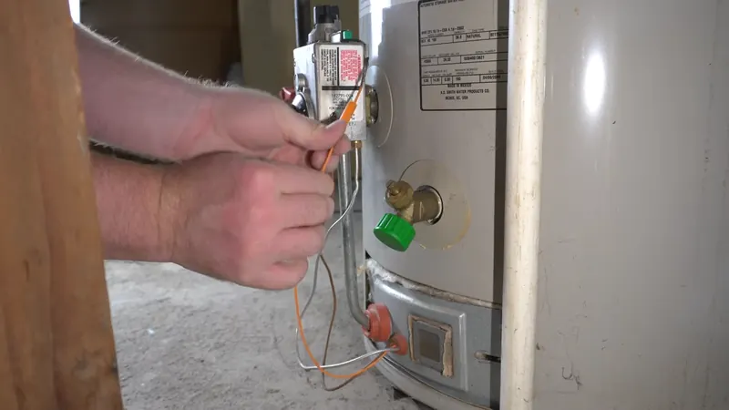 Plumber replacing a thermocouple during gas water heater repair in Chester, PA